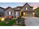 Beautifully landscaped home with stone accents and a cozy front porch seating area, set against a colorful evening sky at 10877 Skydance Dr, Highlands Ranch, CO 80126
