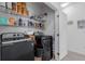 A laundry room boasts sleek black front-load washer and dryer with wire shelving for ample storage at 9185 Wilde Ln # 101, Parker, CO 80134