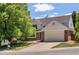 Inviting two-story home with mature trees, brick accents, and a spacious driveway leading to a two-car garage at 5944 E Irwin Pl, Centennial, CO 80112