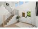 Welcoming foyer featuring a staircase with black iron railings and double doors to the exterior at 5944 E Irwin Pl, Centennial, CO 80112
