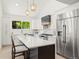 Bright kitchen boasts white cabinets, stainless steel appliances, kitchen island, and pendant lighting at 5944 E Irwin Pl, Centennial, CO 80112