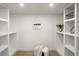 Organized walk-in closet with custom shelving and a comfortable seating area at 5944 E Irwin Pl, Centennial, CO 80112