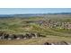 Expansive aerial view of a sprawling neighborhood in a serene, green setting with mountain views at 17102 W 85Th Pl, Arvada, CO 80007