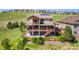 Spacious backyard featuring a large deck, a stone patio, and a well-manicured lawn at 17102 W 85Th Pl, Arvada, CO 80007