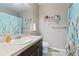 Neutral bathroom with a large mirror, updated lighting, a modern vanity and a decorative blue shower curtain at 17102 W 85Th Pl, Arvada, CO 80007