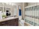 Well-lit bathroom featuring a single sink vanity and patterned shower curtain at 17102 W 85Th Pl, Arvada, CO 80007