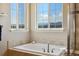Bathroom with a soaking tub; it features two windows and a view of the mountains at 17102 W 85Th Pl, Arvada, CO 80007
