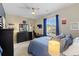 Modern bedroom with dark furniture, plush bedding, and a window providing ample natural light at 17102 W 85Th Pl, Arvada, CO 80007