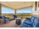 Inviting covered deck with cozy seating and scenic views of the surrounding landscape and distant hills at 17102 W 85Th Pl, Arvada, CO 80007