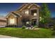 Charming home featuring a manicured lawn, stone accents, and a welcoming front porch at 17102 W 85Th Pl, Arvada, CO 80007