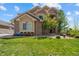 Charming two-story home with stone accents, lush green lawn, and professionally landscaped front yard at 17102 W 85Th Pl, Arvada, CO 80007