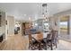 Open-concept living room with hardwood floors, dining area, and a fireplace, offering ample natural light at 17102 W 85Th Pl, Arvada, CO 80007