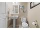 This powder room offers a pedestal sink, neutral tones, and decorative wall art for a stylish, convenient space at 17102 W 85Th Pl, Arvada, CO 80007