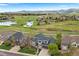 Expansive aerial view showcases a stunning home, lush golf course, serene lake, and majestic mountain backdrop at 6656 S Oak Cir, Littleton, CO 80127