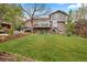Large backyard featuring expansive lawn, brick patio, multiple decks and walkout basement at 6656 S Oak Cir, Littleton, CO 80127