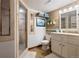 Bathroom with glass shower and vanity with framed mirror, plants and modern lighting at 6656 S Oak Cir, Littleton, CO 80127