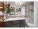 Bathroom featuring a large mirror, vanity with gray cabinets and shower/tub combo at 6656 S Oak Cir, Littleton, CO 80127