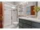 Updated bathroom featuring a glass enclosed shower and large vanity with gray cabinets at 6656 S Oak Cir, Littleton, CO 80127
