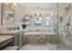 Updated bathroom featuring vanity with gray cabinets, soaking tub, and a glass enclosed shower at 6656 S Oak Cir, Littleton, CO 80127
