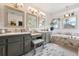 Bright bathroom featuring double sinks, generous vanity space, and a soaking tub with marble surround at 6656 S Oak Cir, Littleton, CO 80127