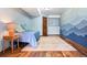 Bright bedroom with wood floors, blue accent wall and colorful area rug at 6656 S Oak Cir, Littleton, CO 80127