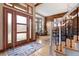 Elegant foyer features hardwood floors, a wood accent wall, and staircase at 6656 S Oak Cir, Littleton, CO 80127