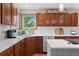 Well-lit eat-in kitchen featuring stainless steel appliances, custom wood cabinets, and white quartz countertops at 6656 S Oak Cir, Littleton, CO 80127
