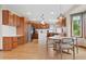 Bright eat-in kitchen boasts custom wood cabinets, stainless steel appliances, hardwood floors, and quartz countertops at 6656 S Oak Cir, Littleton, CO 80127