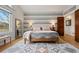 Relaxing main bedroom features a decorative accent wall, wood flooring, and a full-length mirror at 6656 S Oak Cir, Littleton, CO 80127