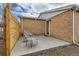 Enclosed brick back patio features two chairs and privacy from a wood fence at 8105 W 62Nd Ave, Arvada, CO 80004