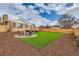 Charming backyard featuring an outdoor firepit, seating area, lush artificial grass, and wood fence at 8105 W 62Nd Ave, Arvada, CO 80004