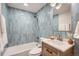 This bathroom features stylish blue tiles, a modern vanity, and a combined tub and shower for a refreshing experience at 8105 W 62Nd Ave, Arvada, CO 80004