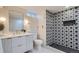 Modern bathroom features a striking black-and-white tiled shower and sleek vanity with stylish lighting at 8105 W 62Nd Ave, Arvada, CO 80004