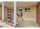 Inviting front porch with brick accents, plants, and a stylish red door entrance at 8105 W 62Nd Ave, Arvada, CO 80004