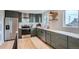 Updated kitchen featuring stainless steel appliances, olive green cabinetry and hardwood floors at 8105 W 62Nd Ave, Arvada, CO 80004