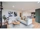 Open living area featuring a cozy seating arrangement, modern art, and hardwood floors, connecting to the adjacent kitchen at 8105 W 62Nd Ave, Arvada, CO 80004