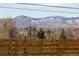 Beautiful mountain views from the home, framed by a wooden fence and trees at 8105 W 62Nd Ave, Arvada, CO 80004