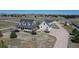 Expansive horse property featuring a light gray home with white trim, a covered porch, paddocks, and stables at 1465 Arabian Trl, Elizabeth, CO 80107
