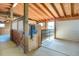 Inside a horse barn with wooden beams, horse stall, and tack at 1465 Arabian Trl, Elizabeth, CO 80107