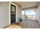 Charming covered porch with wood flooring, a black front door, and a view of the property's expansive surroundings at 1465 Arabian Trl, Elizabeth, CO 80107