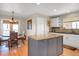 Eat-in kitchen with a kitchen island, dining table set, and white cabinets and wood floors at 1465 Arabian Trl, Elizabeth, CO 80107