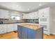 Bright kitchen with white cabinets, a large center island, stainless steel appliances, and hardwood floors at 1465 Arabian Trl, Elizabeth, CO 80107