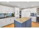 Bright kitchen features stainless appliances, white cabinetry, granite countertops, and hardwood floors at 1465 Arabian Trl, Elizabeth, CO 80107