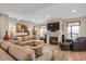 Cozy living room featuring a fireplace with a large TV above it, a comfortable sectional sofa, and hardwood floors at 1465 Arabian Trl, Elizabeth, CO 80107
