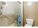Bathroom with glass-door shower with grab bar, towel, and toilet at 3274 S Heather Gardens Way, Aurora, CO 80014