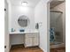 Bright bathroom featuring stylish vanity, mirror, and a glass-enclosed shower stall at 3274 S Heather Gardens Way, Aurora, CO 80014