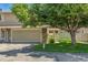 Two-car garage on exterior of home has green grass and mature tree in the front yard at 3274 S Heather Gardens Way, Aurora, CO 80014