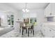 Bright eat-in kitchen with white cabinets, a marble-patterned floor, and a sunlit window at 3274 S Heather Gardens Way, Aurora, CO 80014