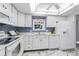 Updated kitchen featuring white appliances, cabinets, and marble flooring with blue accents at 3274 S Heather Gardens Way, Aurora, CO 80014