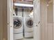 Laundry closet with full-size washer and dryer units behind bi-fold doors at 3274 S Heather Gardens Way, Aurora, CO 80014